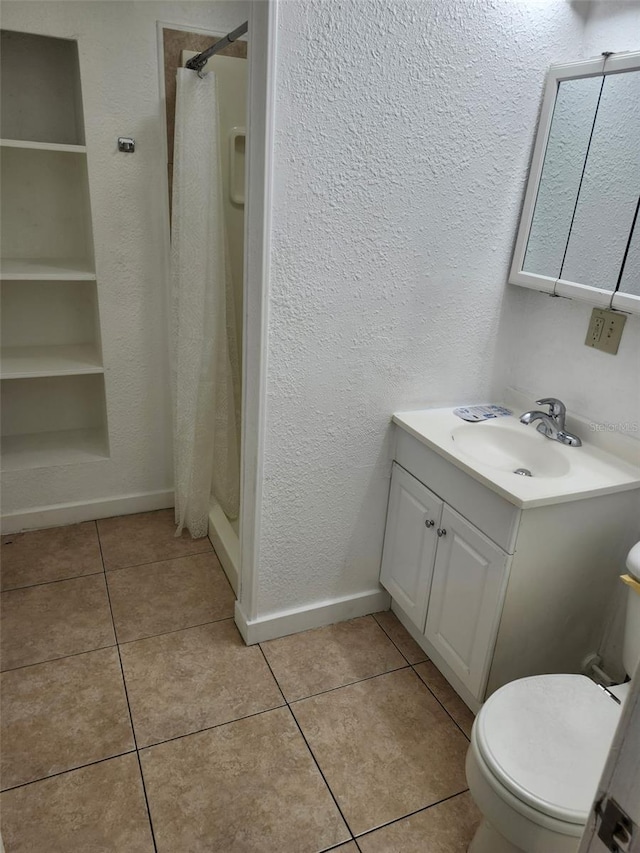 full bath featuring tile patterned floors, baseboards, toilet, and a shower stall