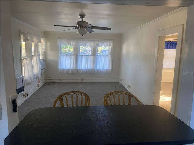 unfurnished dining area featuring ceiling fan, baseboards, ornamental molding, and carpet flooring