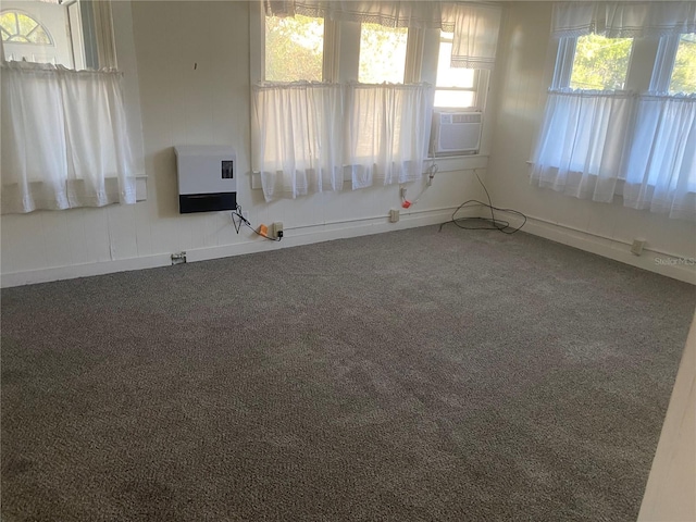 empty room with carpet flooring, heating unit, and cooling unit