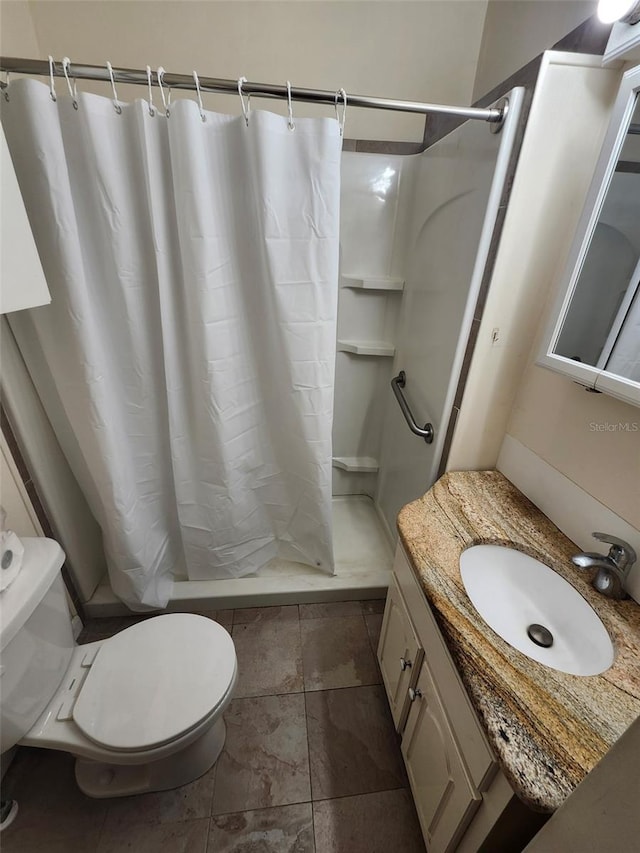 bathroom featuring vanity, a shower stall, and toilet