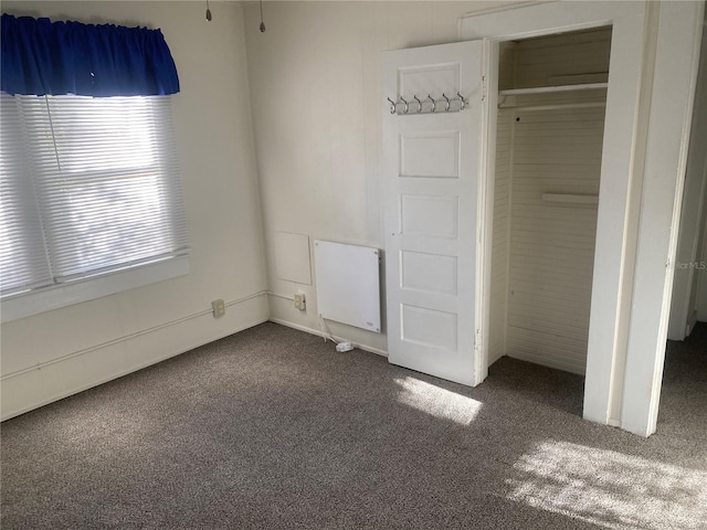 unfurnished bedroom with a closet and dark carpet