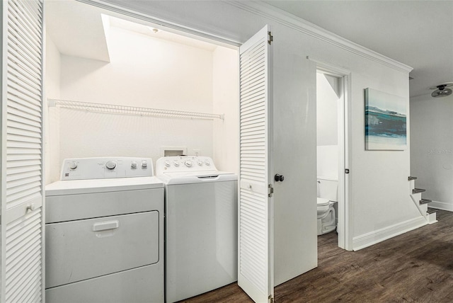 clothes washing area with ornamental molding, dark hardwood / wood-style floors, and separate washer and dryer