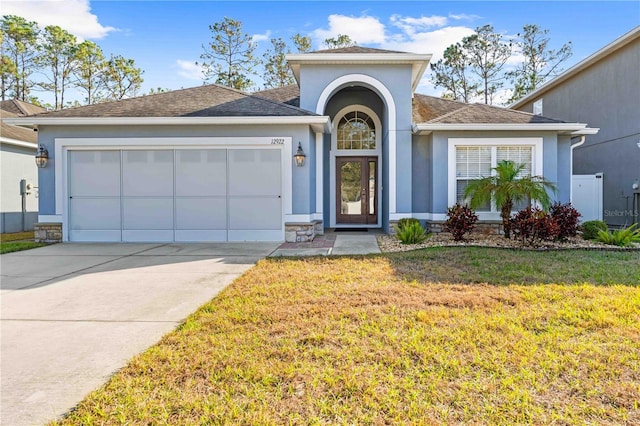 ranch-style house with a garage and a front lawn