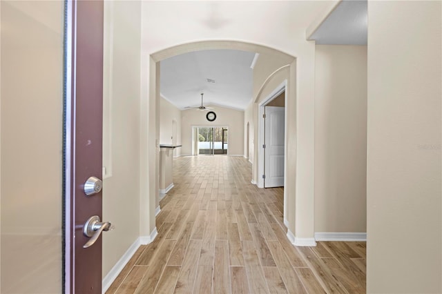 hall featuring vaulted ceiling and light hardwood / wood-style floors