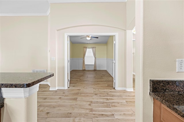 hallway with crown molding and light hardwood / wood-style floors