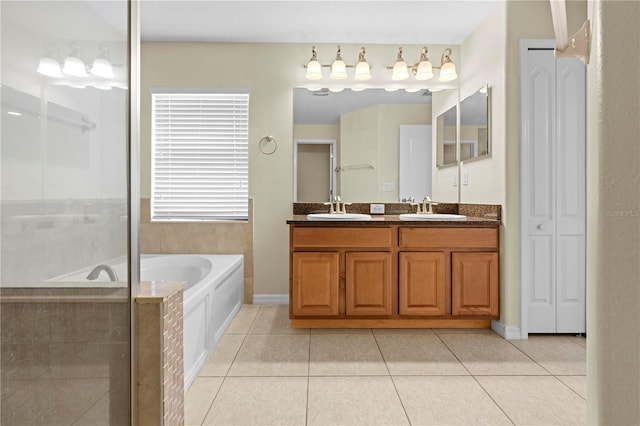 bathroom with tile patterned flooring, a tub to relax in, and vanity