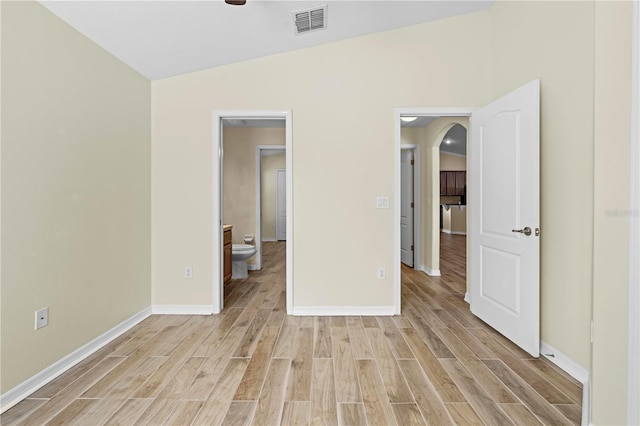 unfurnished bedroom featuring connected bathroom and vaulted ceiling