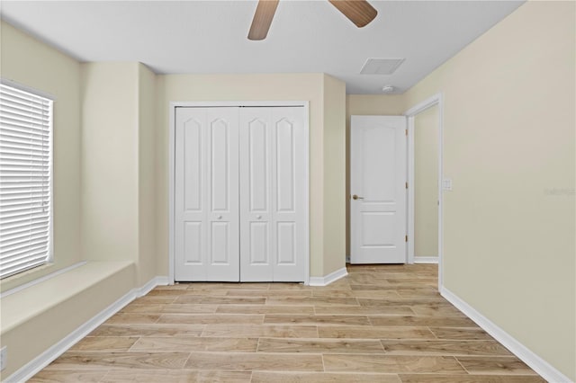 unfurnished bedroom with light hardwood / wood-style flooring, a closet, and ceiling fan