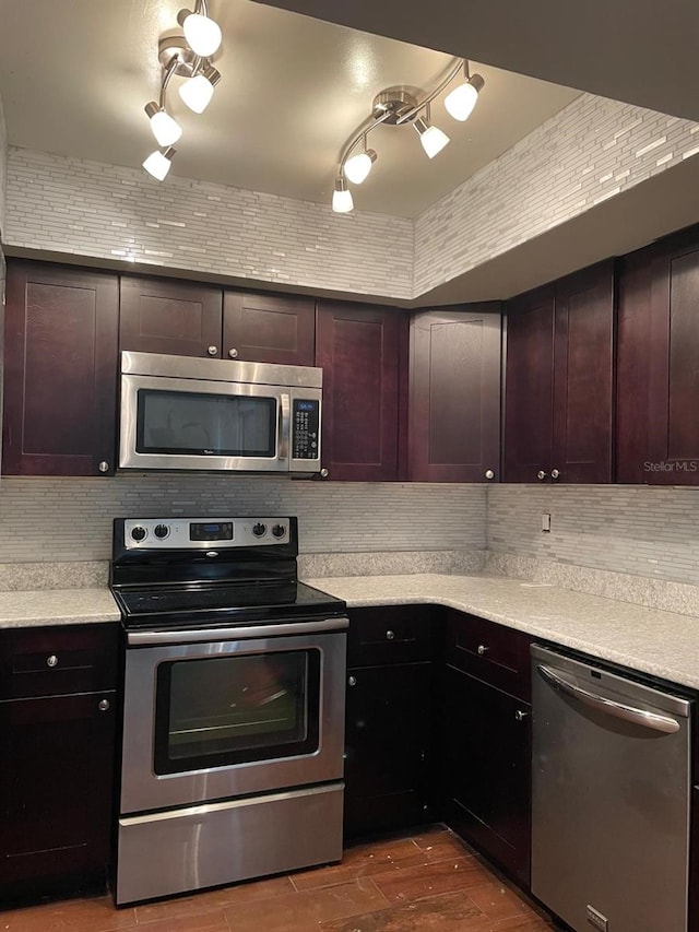 kitchen with hardwood / wood-style flooring, tasteful backsplash, appliances with stainless steel finishes, and dark brown cabinets