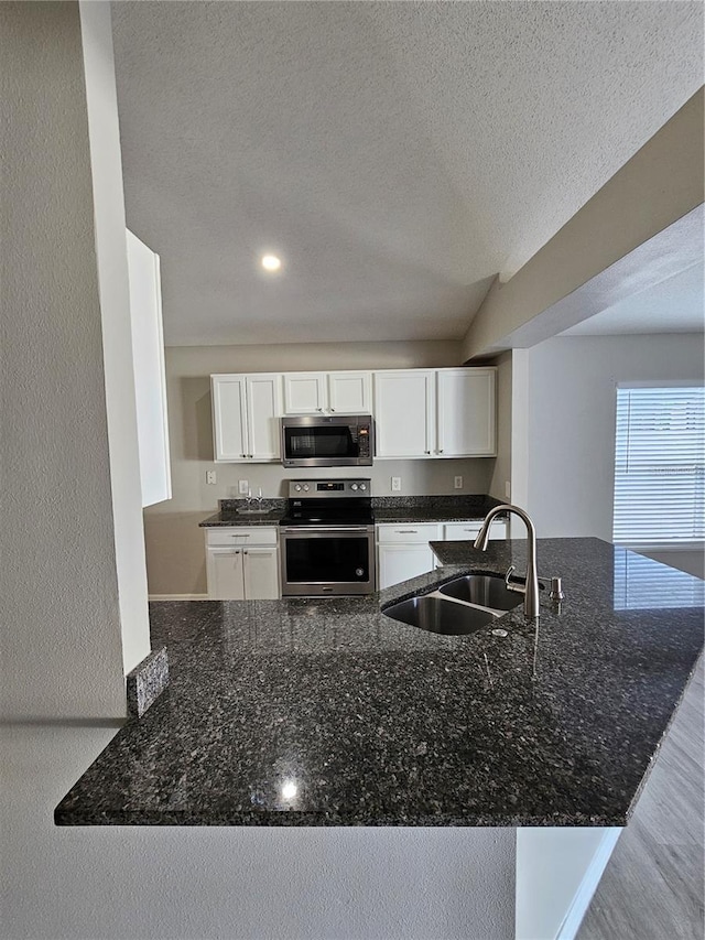 kitchen featuring white cabinetry, appliances with stainless steel finishes, sink, and kitchen peninsula