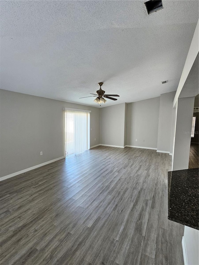 unfurnished living room with ceiling fan, a textured ceiling, and dark hardwood / wood-style flooring