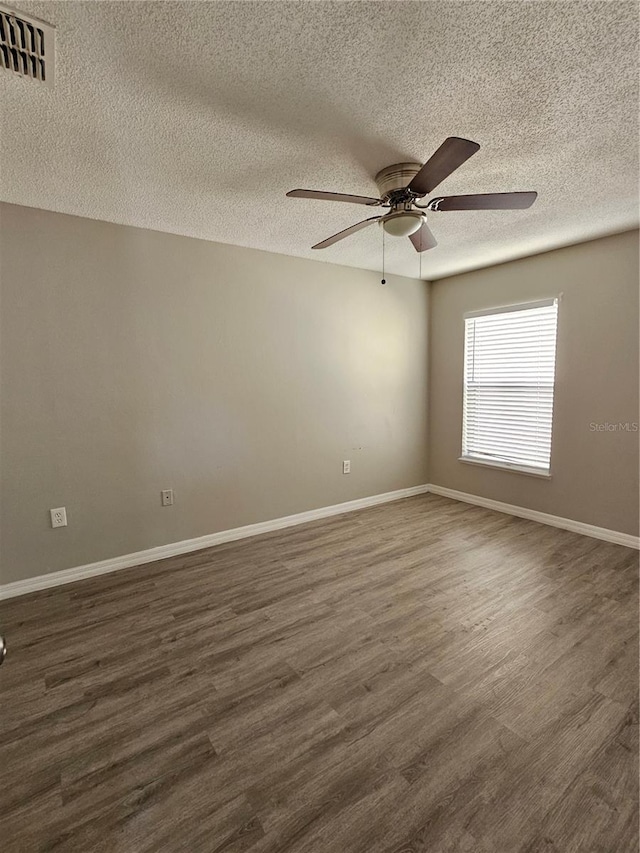 unfurnished room featuring ceiling fan, dark hardwood / wood-style floors, and a textured ceiling