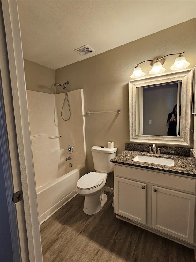 full bathroom featuring wood-type flooring, toilet, vanity, and shower / bathing tub combination