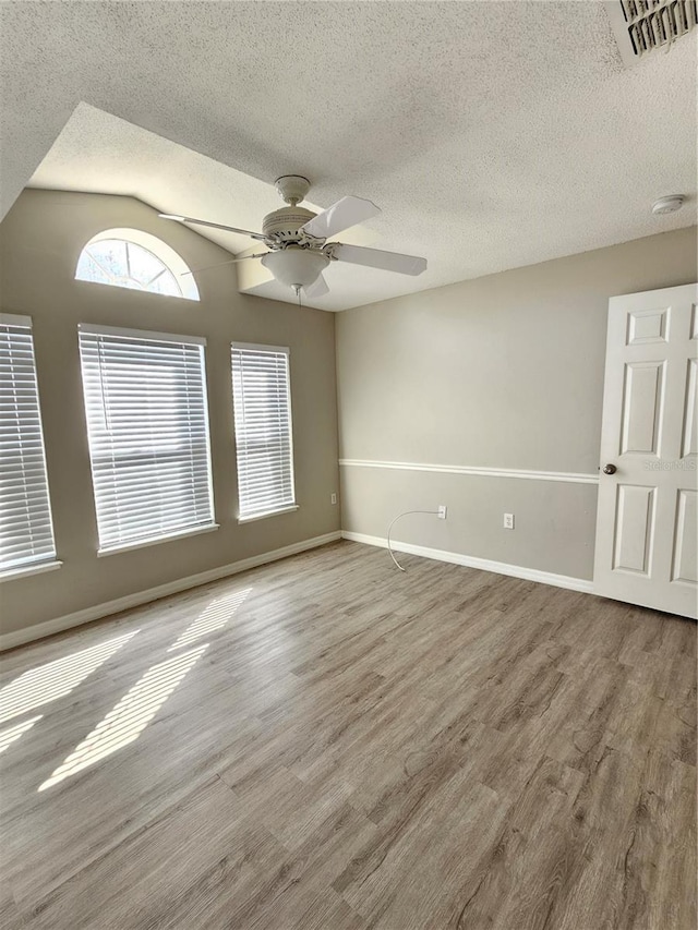 empty room featuring hardwood / wood-style flooring, a textured ceiling, and ceiling fan