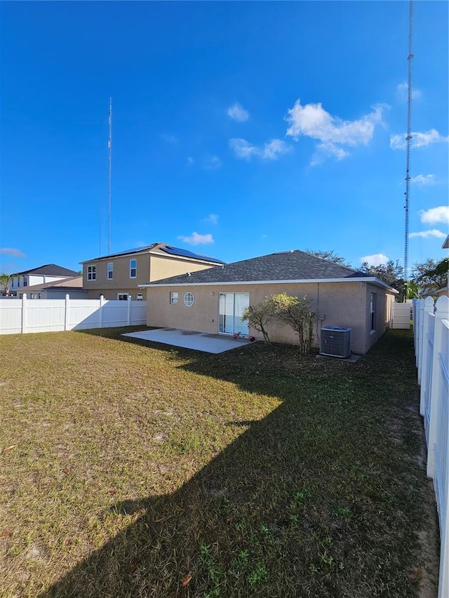 back of property with central AC unit, a yard, and a patio area