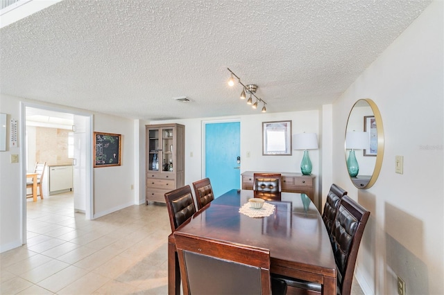 dining area with light tile patterned flooring and a textured ceiling