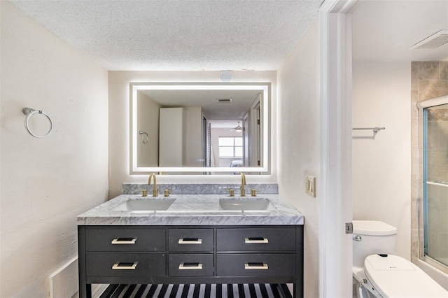 bathroom featuring vanity, a textured ceiling, and toilet