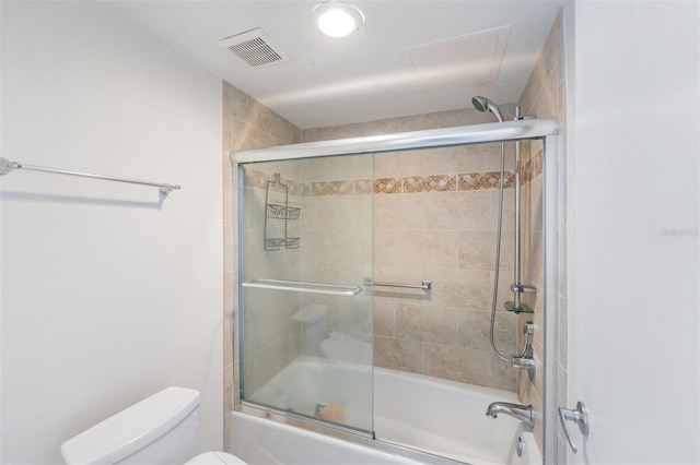 bathroom featuring combined bath / shower with glass door and toilet