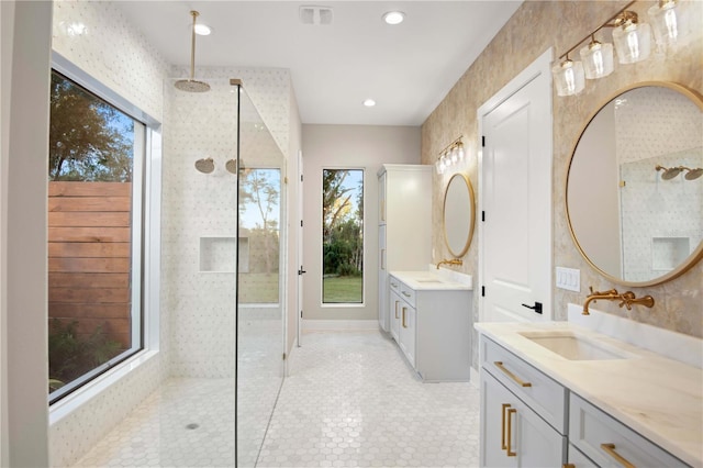 bathroom featuring tiled shower and vanity