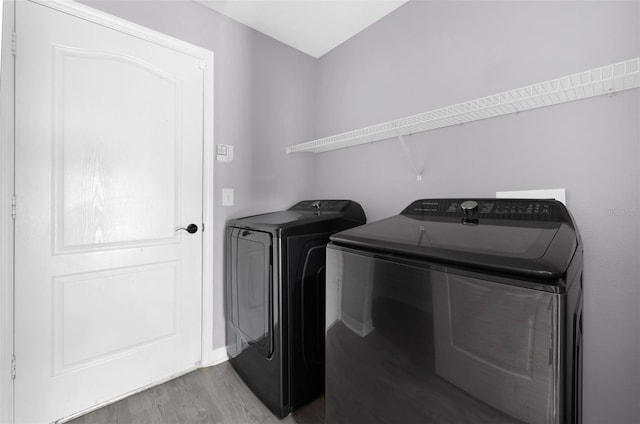 laundry area featuring independent washer and dryer and light hardwood / wood-style flooring