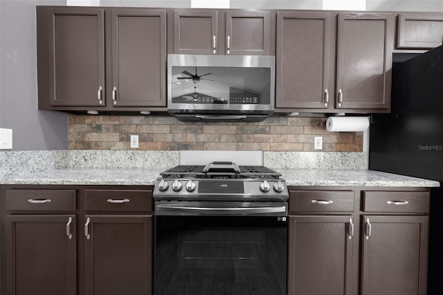 kitchen with light stone counters, dark brown cabinetry, appliances with stainless steel finishes, and tasteful backsplash