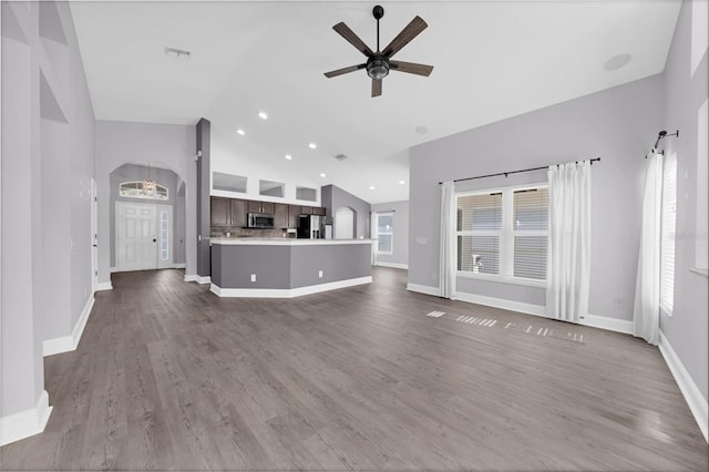 unfurnished living room featuring high vaulted ceiling, dark hardwood / wood-style floors, and ceiling fan