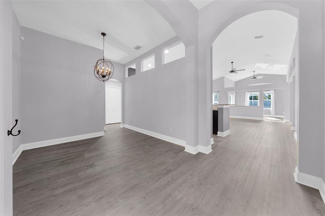 interior space featuring vaulted ceiling, ceiling fan with notable chandelier, and dark hardwood / wood-style flooring