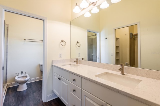 bathroom with a bidet, hardwood / wood-style flooring, vanity, a notable chandelier, and toilet