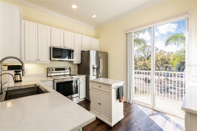 kitchen with sink, stainless steel appliances, a center island, ornamental molding, and white cabinets