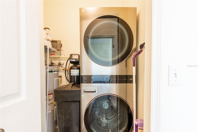 laundry room featuring stacked washer / drying machine and electric water heater