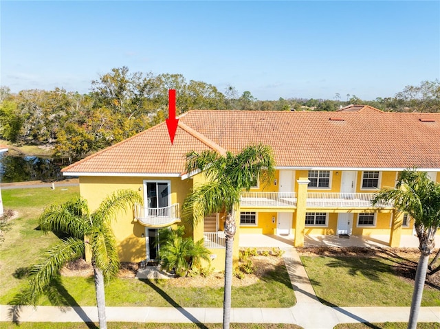 view of front of home featuring a front lawn, a patio, and a balcony