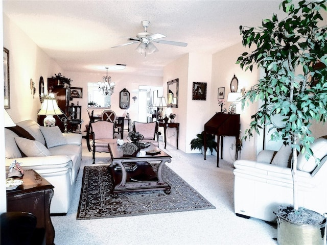 living room featuring ceiling fan with notable chandelier and a textured ceiling