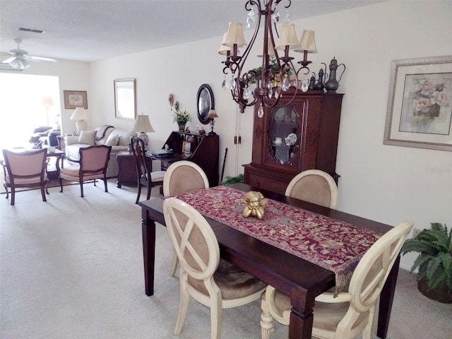 carpeted dining room featuring ceiling fan with notable chandelier