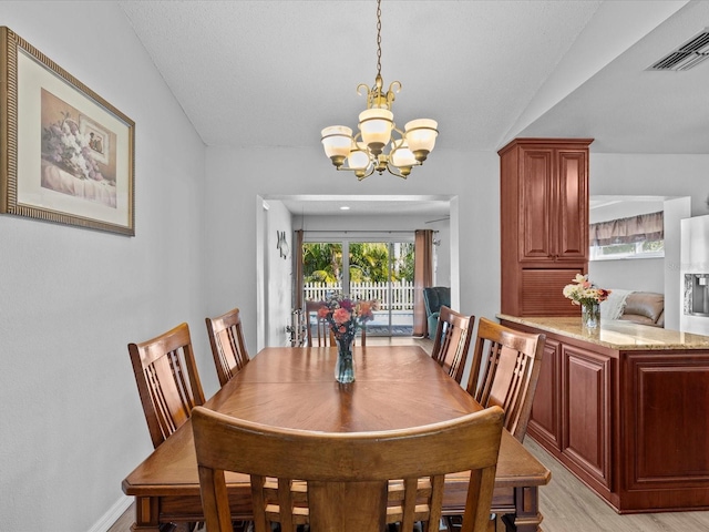 dining space with light hardwood / wood-style flooring, a notable chandelier, and vaulted ceiling