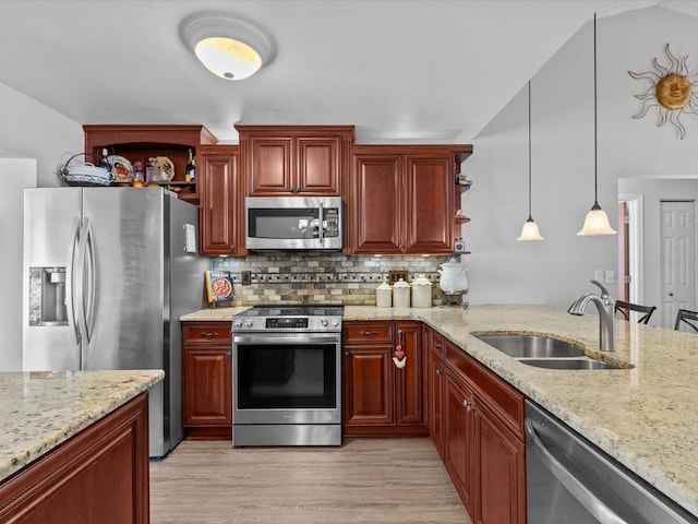 kitchen with appliances with stainless steel finishes, decorative light fixtures, sink, backsplash, and light hardwood / wood-style floors