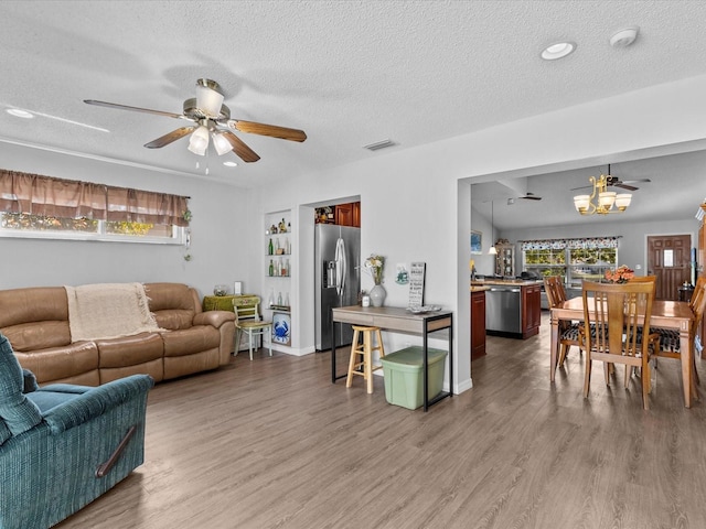 living room with ceiling fan, hardwood / wood-style floors, and a textured ceiling