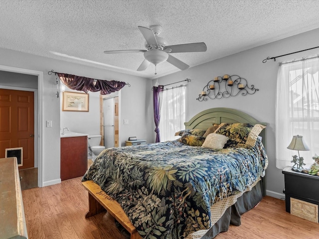 bedroom with ceiling fan, light hardwood / wood-style floors, and a textured ceiling