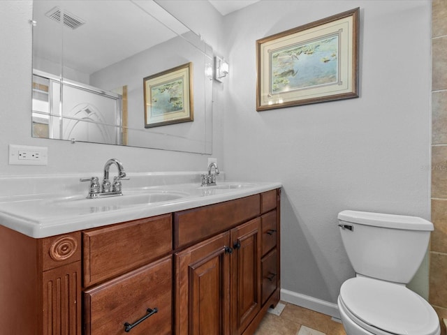 bathroom with vanity, toilet, and a shower with door