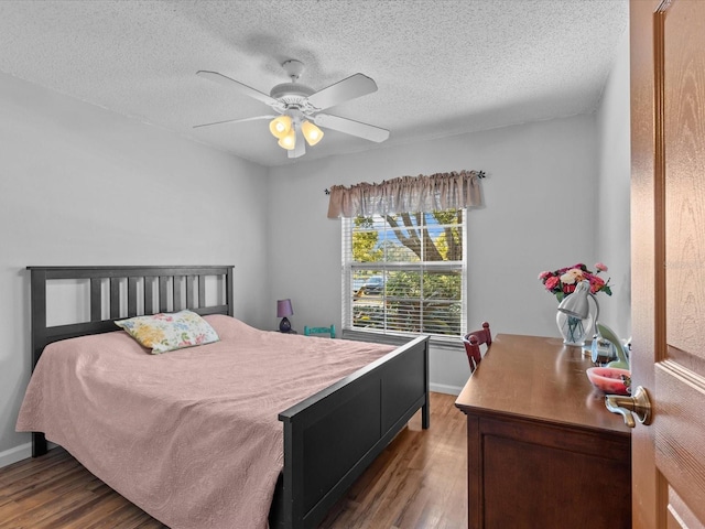 bedroom featuring ceiling fan, hardwood / wood-style floors, and a textured ceiling