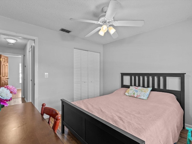 bedroom with ceiling fan, a textured ceiling, and a closet