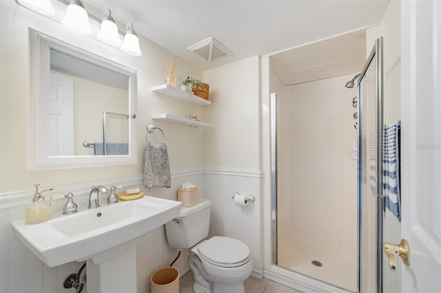 bathroom with a shower with shower door, sink, tile patterned floors, and toilet