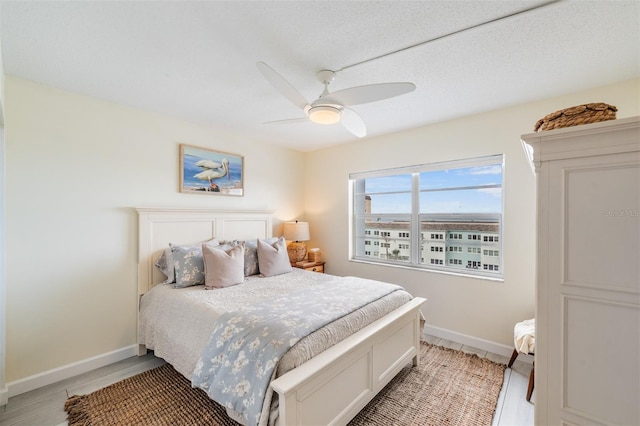 bedroom with ceiling fan and a textured ceiling