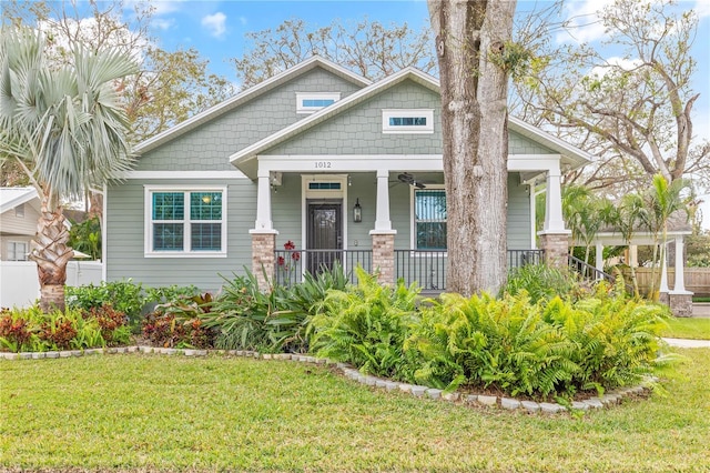 craftsman inspired home featuring a front lawn and covered porch