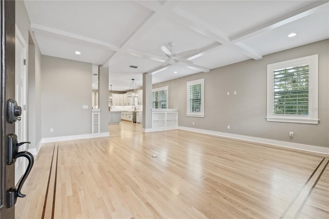 unfurnished living room with coffered ceiling, beam ceiling, light hardwood / wood-style floors, and ceiling fan