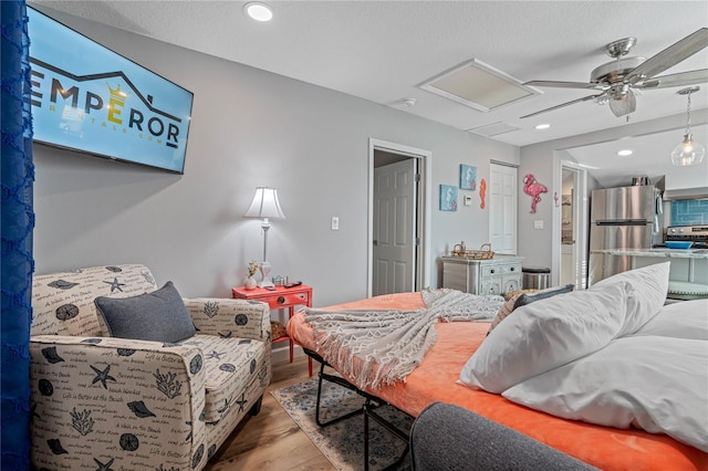 bedroom featuring hardwood / wood-style floors, stainless steel fridge, and ceiling fan