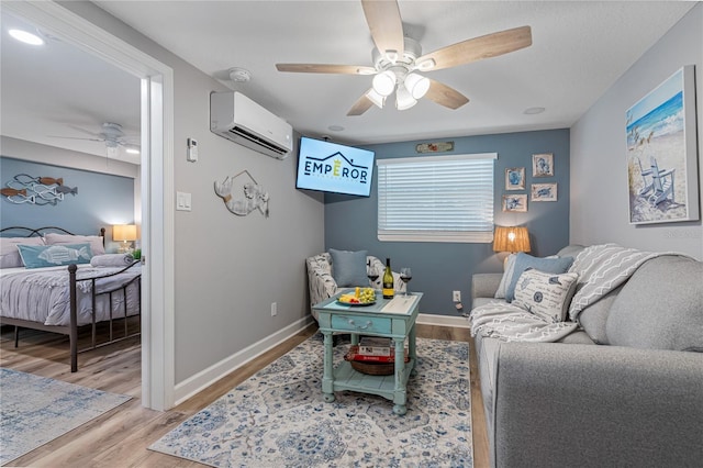 living room with light hardwood / wood-style flooring, a wall unit AC, and ceiling fan