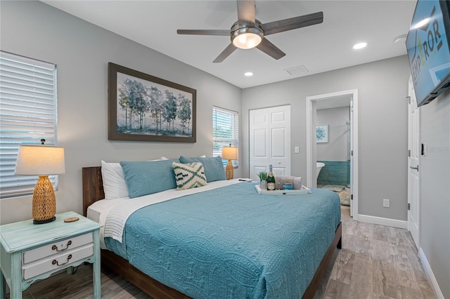 bedroom with hardwood / wood-style flooring, ceiling fan, and connected bathroom