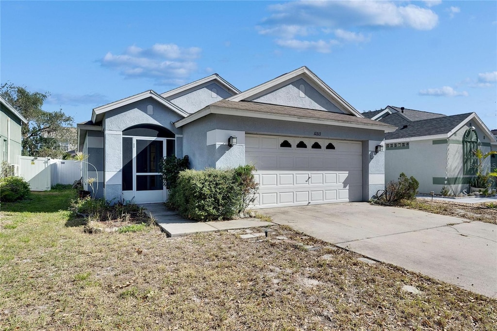 ranch-style house featuring a garage and a front lawn