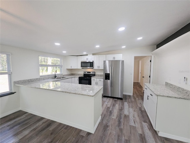 kitchen with appliances with stainless steel finishes, white cabinetry, sink, kitchen peninsula, and light stone countertops