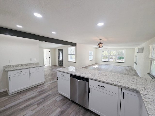 kitchen with white cabinetry, hanging light fixtures, stainless steel dishwasher, light hardwood / wood-style floors, and light stone countertops